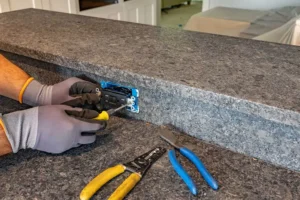 electrician from Jeremy Electrical installing kitchen island outlet in Kansas City