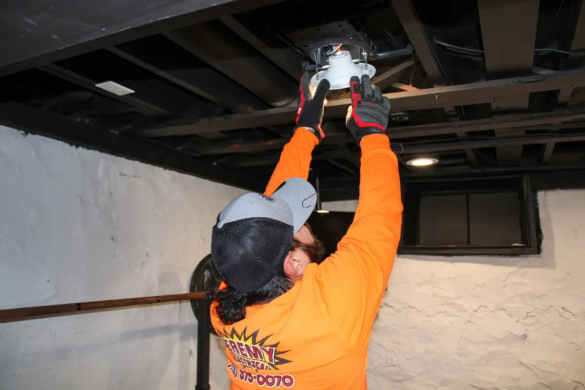 electrician installing lights in the ceiling for Jeremy Electrical in Roeland Park, KS