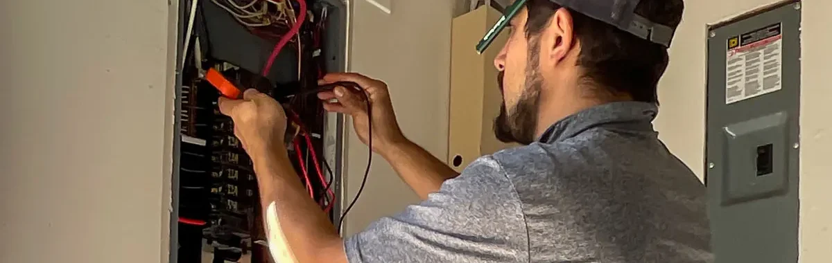 electrician from Jeremy Electrical in front of an electrical panel performing an electrical inspection