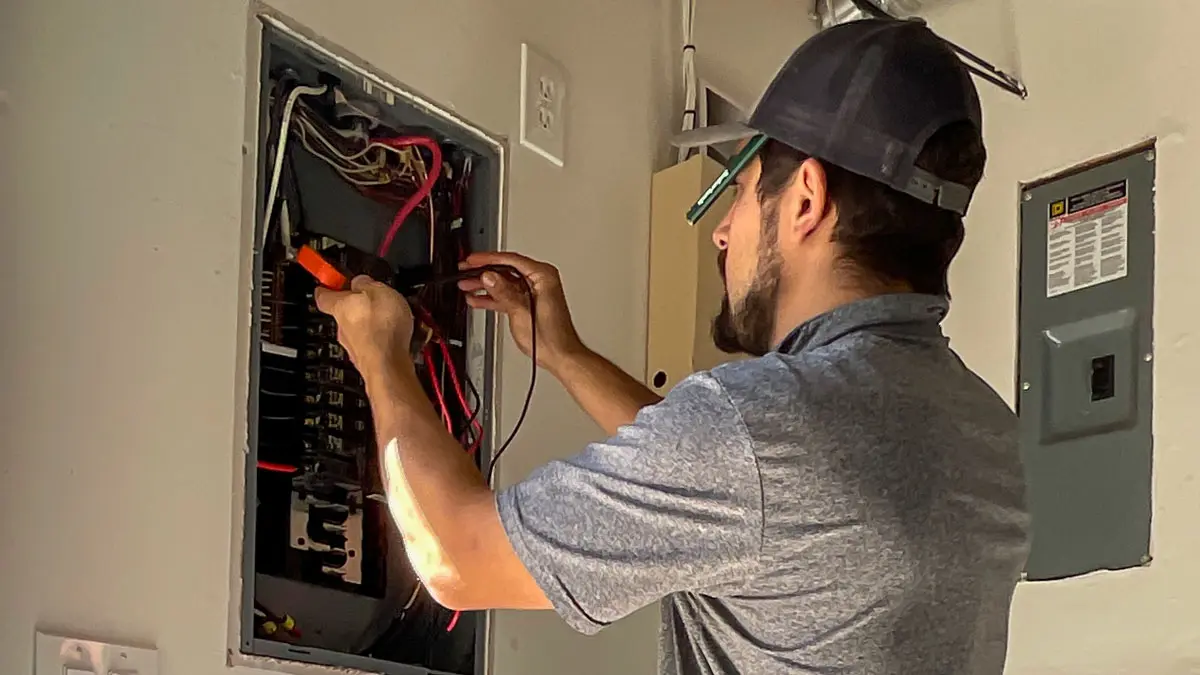 electrician from Jeremy Electrical in front of an electrical panel performing an electrical inspection